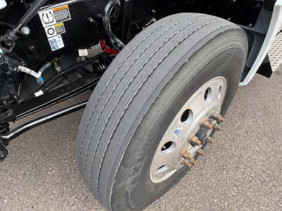 Kenworth T880 front wheel hub and tire showing dual rear axle design and wheel bolts.