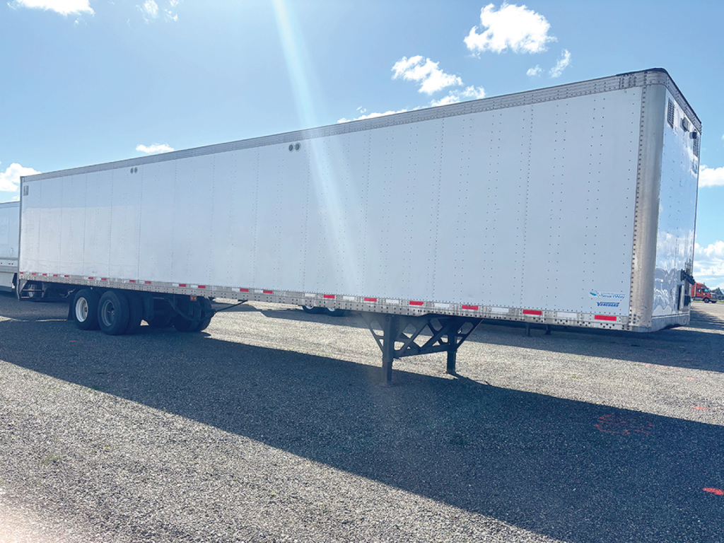 2018 Vanguard aluminum dry van trailer side view showing smooth aluminum panels and tandem axles with landing gear.