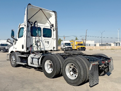 Tractor truck rear three-quarter view showing Freightliner Cascadia 116 chassis with dual rear axles and open sleeper cab.