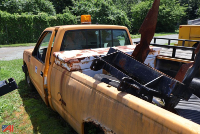 Chevrolet 1993 C/K 1500 pickup truck with rusted bed and equipment in the truck bed, orange warning beacon on cab, side view showing double cab and pickup bed.