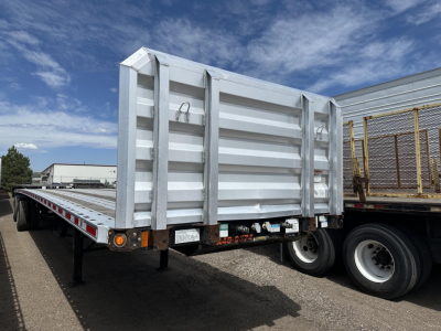 Flatbed trailer at rear view showing tall vertical side panels and tail light area of a Fontaine Infinity trailer.