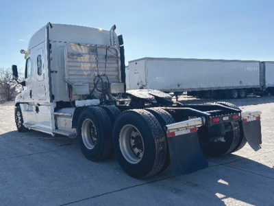 Conventional sleeper Freightliner Cascadia125 tractor rear view showing tandem axle, mud flaps, and fifth-wheel plate.