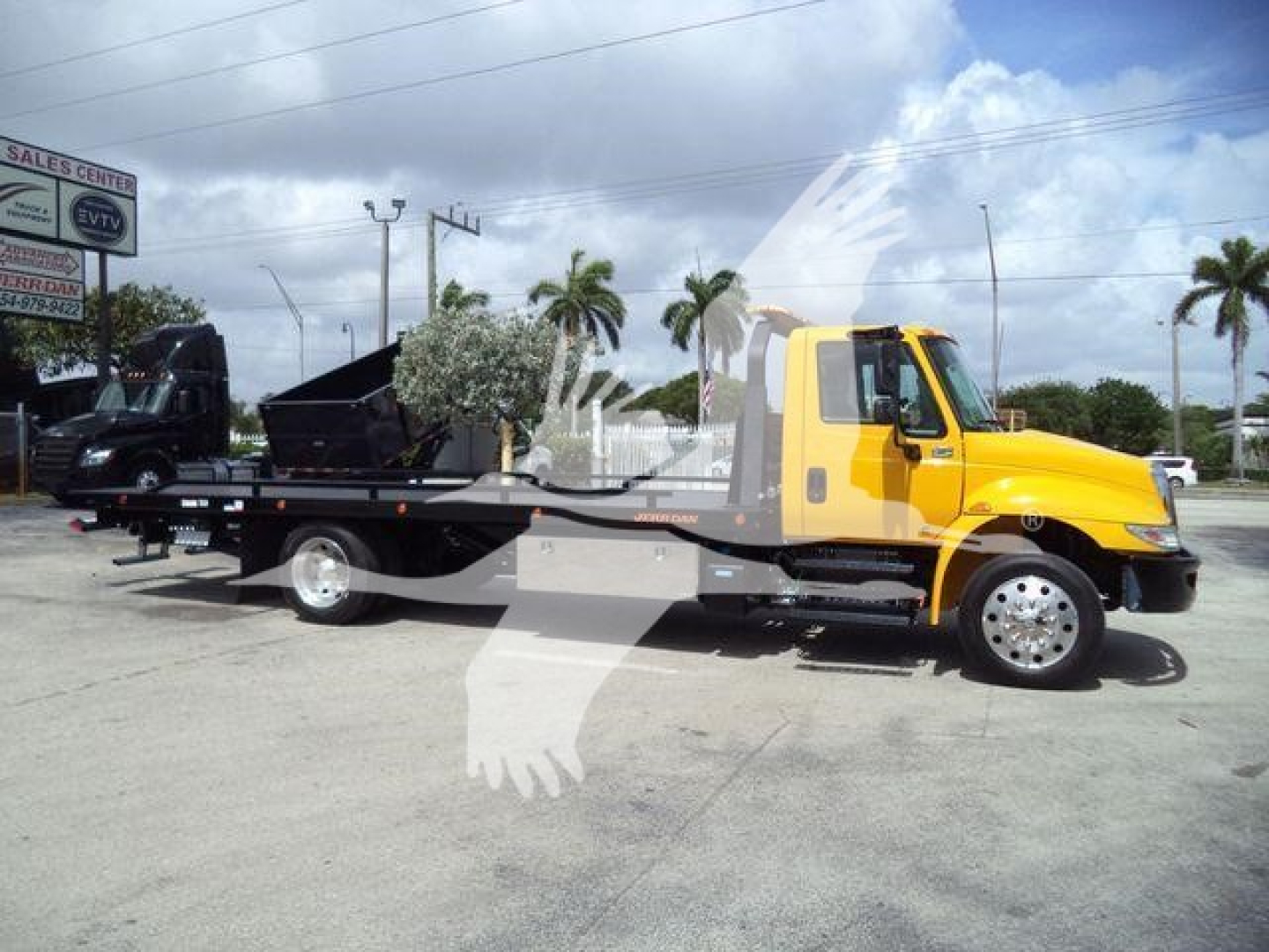 2019 International 4300 rollback tow truck with a yellow cab and black flatbed, side view, stock number T12255FM visible in the image.