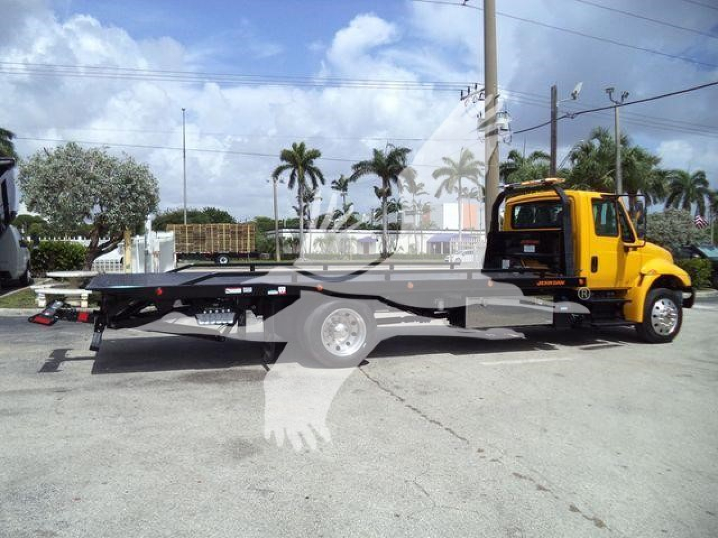 2019 International 4300 rollback truck in profile view with yellow cab and flatbed, stock number T12255FM.