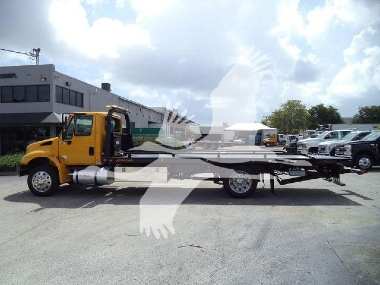 2019 International 4300 rollback tow truck side view showing cab and flatbed with branding not legible.