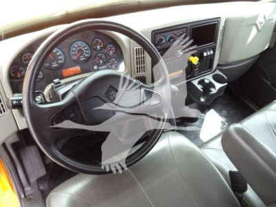 Interior of a 2019 International 4300 truck showing steering wheel, dashboard Gauges, console with cup holders and controls.