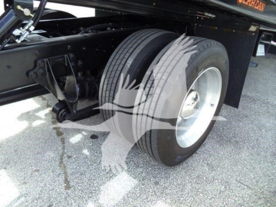 Truck chassis near dual rear wheels showing suspension and tire details on a 2019 International 4300 rollback.