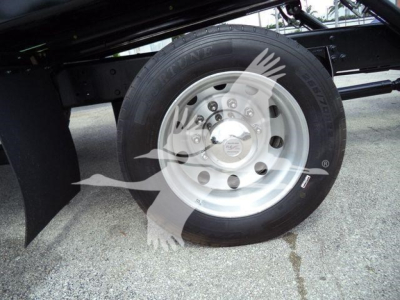 Wheel and tire on a 2019 International 4300 rollback truck showing front steel rim and Hankook tire with hubcap and surrounding chassis.