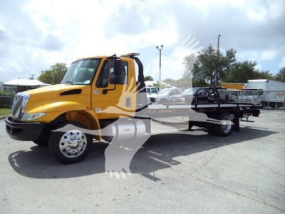 Yellow International 4300 tow truck with flatbed seen from front-left angle; no legible labels visible on image itself.