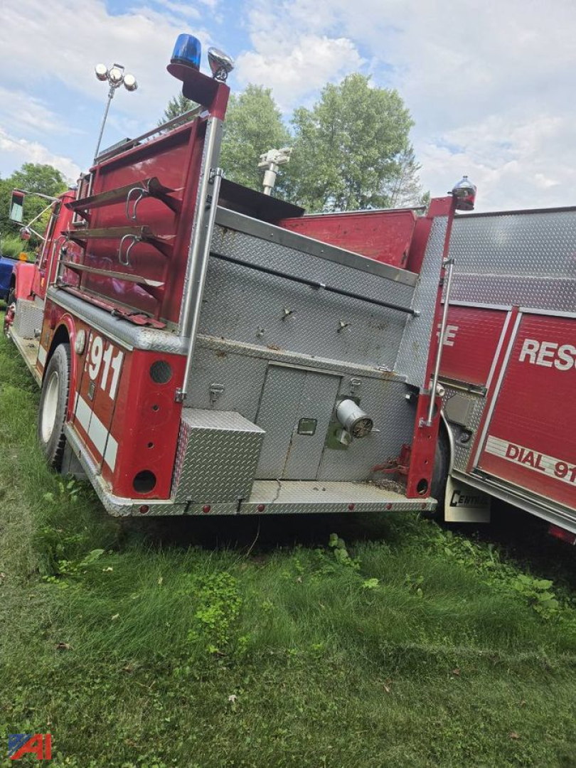 Fire truck rear quarter showing equipment bay doors and ladder storage with '9311' visible on the side.