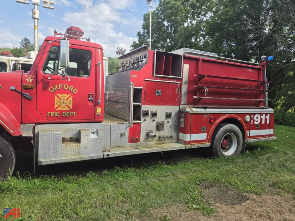 Red firetruck in-service showing Oxford Fire Dept. emblem and 911 on rear wheel well