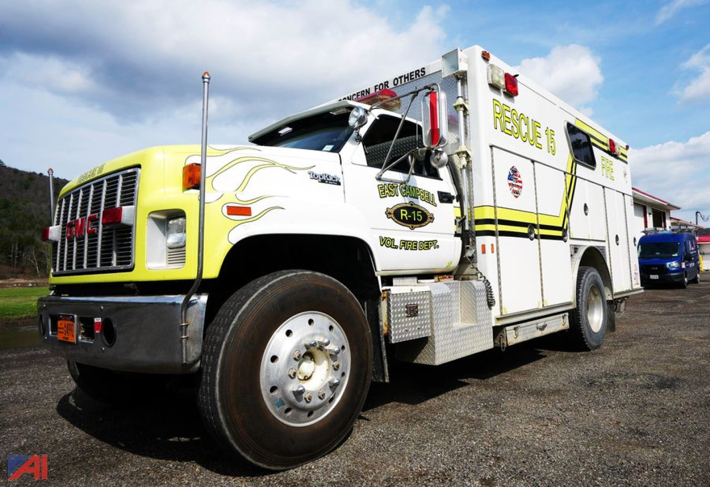 GMC Topkick E-One rescue truck with yellow front grill and white body; Rescue 15 text on side; flames decal near front; 'BEST PRACTICE' and other small decals on door; emergency lights and compartments; firefighter lettering along with 'RES