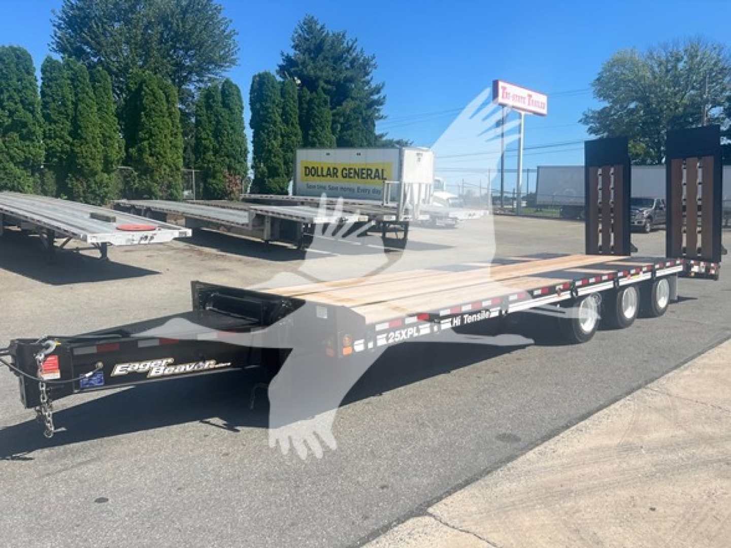 Flatbed trailer showing lower deck with dual rear axles and branding; visible text includes 25XPXL and Eager Beaver on the tongue.