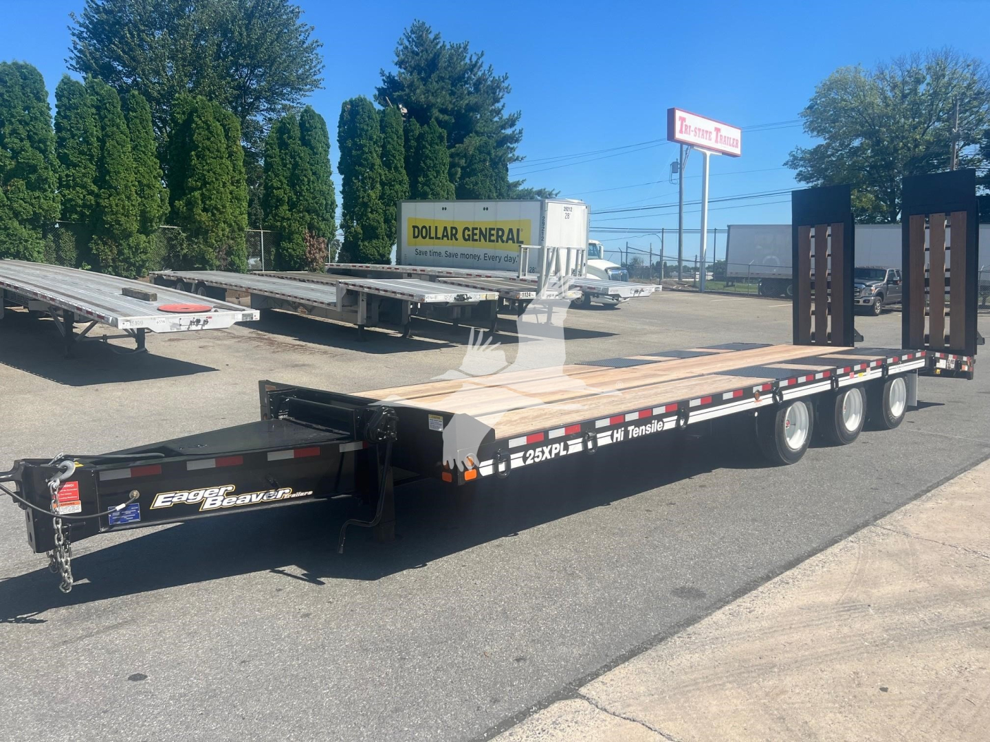 Trailer flatbed with low-profile gooseneck showing 25XPL model name and DOT lights in a parking lot.
