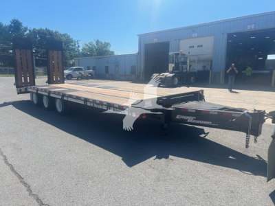 Trailer deck of a 2026 Eager Beaver 25XPL flatbed trailer viewed from side showing gooseneck, tandem axles, and ramps; branding 'Eager Beaver' and Stiles Trucks near front.