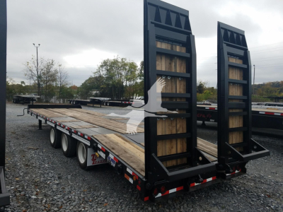 Trailer deck showing ramp system vertical boards and wooden deck with dual rear ramps and tag trailer frame.
