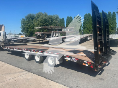 Trailer showing flatbed equipment with dual rear axles and a raised gooseneck in-service.