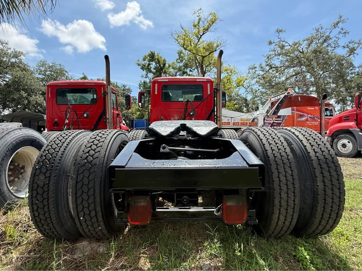 Rear view of a Mack CXU613 truck chassis showing dual rear axles and fifth wheel mount.
