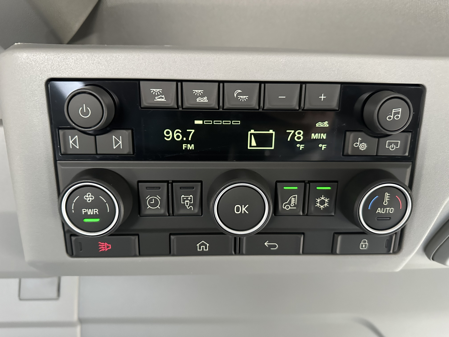 Truck cab control panel showing radio display 96.7 FM, inside cabin with various buttons, knobs, and indicators.