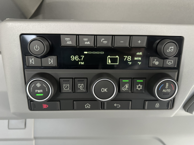 Truck cab control panel showing radio display 96.7 FM, inside cabin with various buttons, knobs, and indicators.