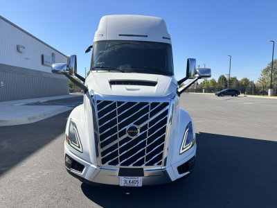 Front view of a white 2025 Volvo VNL64T860 truck showing prominent grille, headlights, and side mirrors.