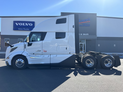 Volvo VNL64T860 sleeper cab tractor in white parked outside dealership with Volvo Trucks sign