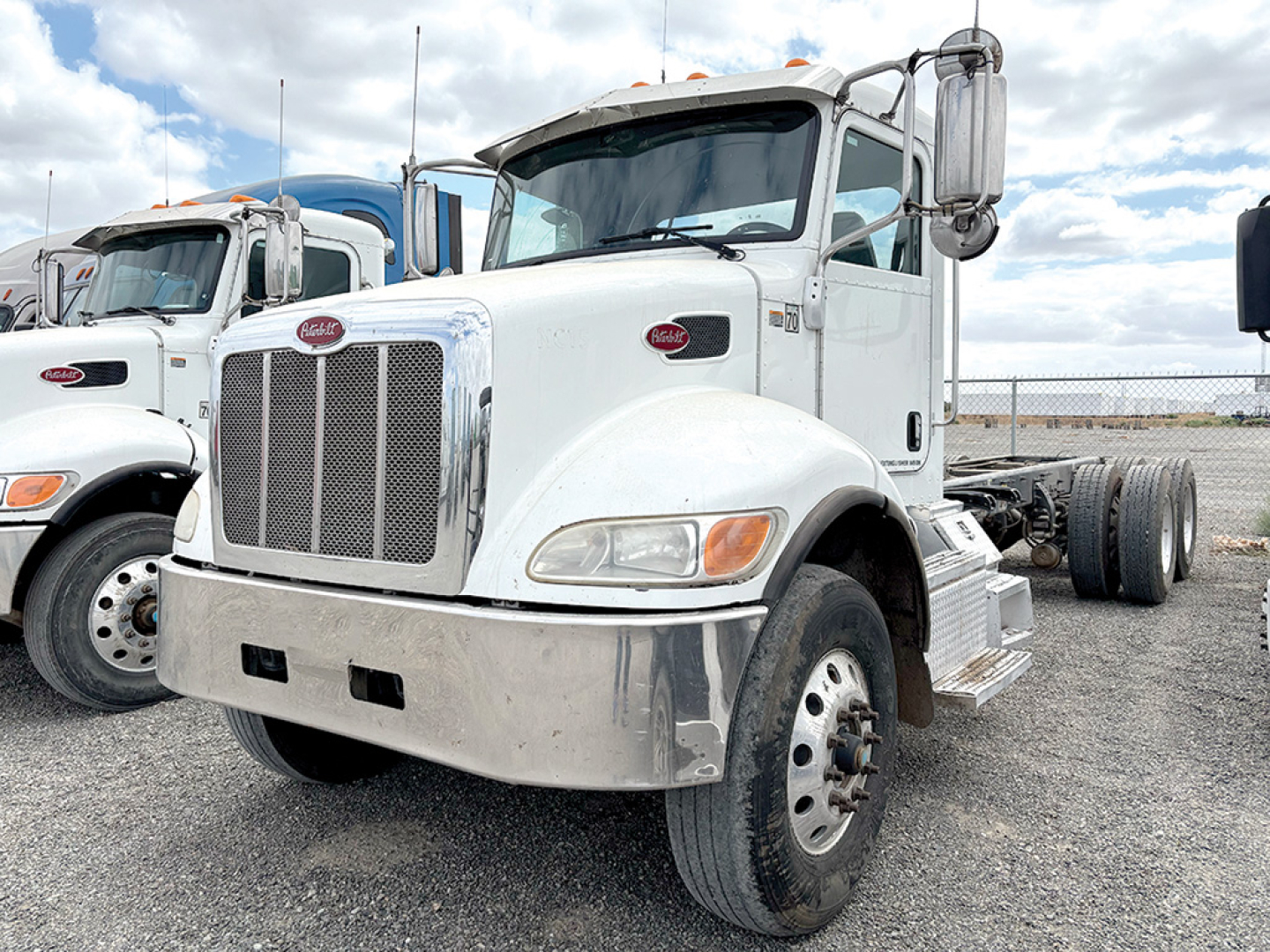 Peterbilt 348 cab and chassis front view showing chrome grille, headlights, and white exterior with dual rear wheel absent in the image.