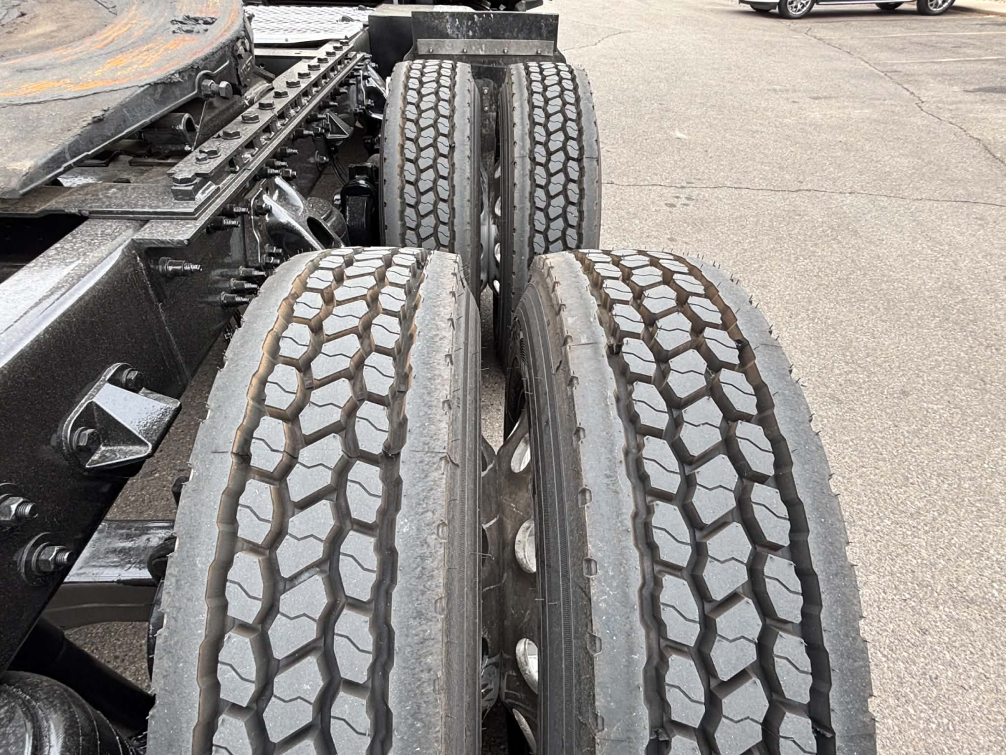 Kenworth T680 rear dual tandem wheels with heavy tread on tires, chassis frame and fifth wheel visible.
