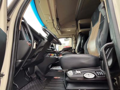 Kenworth T680 interior driver's seat and dashboard view with steering wheel, control console, and pedals.