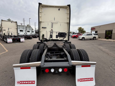 Kenworth T680 truck cab rear view showing fifth wheel and dual rear axles with Kenworth branding on mud flaps.