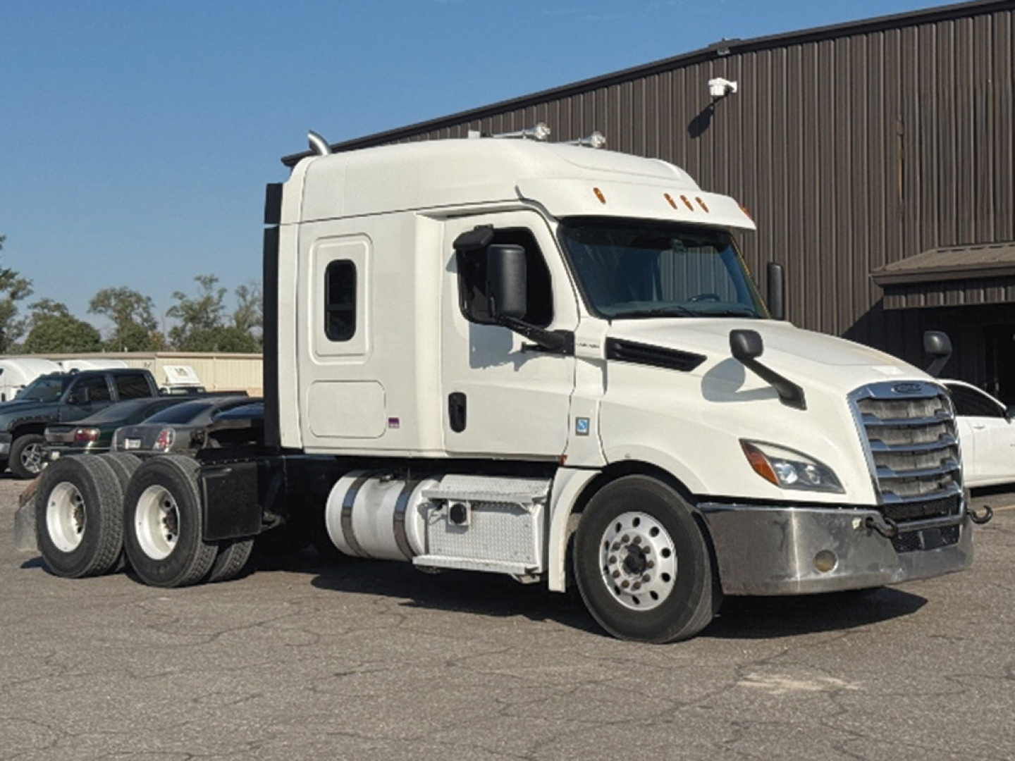 Truck cab forward view showing 2020 Freightliner Cascadia126 sleeper tractor with white paint and dual rear axles.