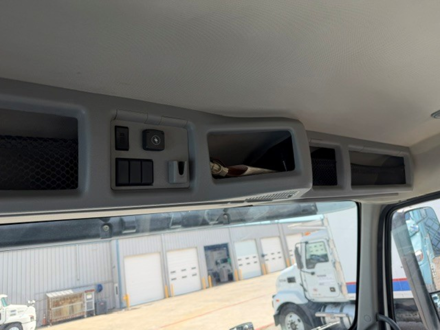 Interior cab ceiling and overhead switches of a Volvo VNR truck showing storage compartments and control panel in light gray.