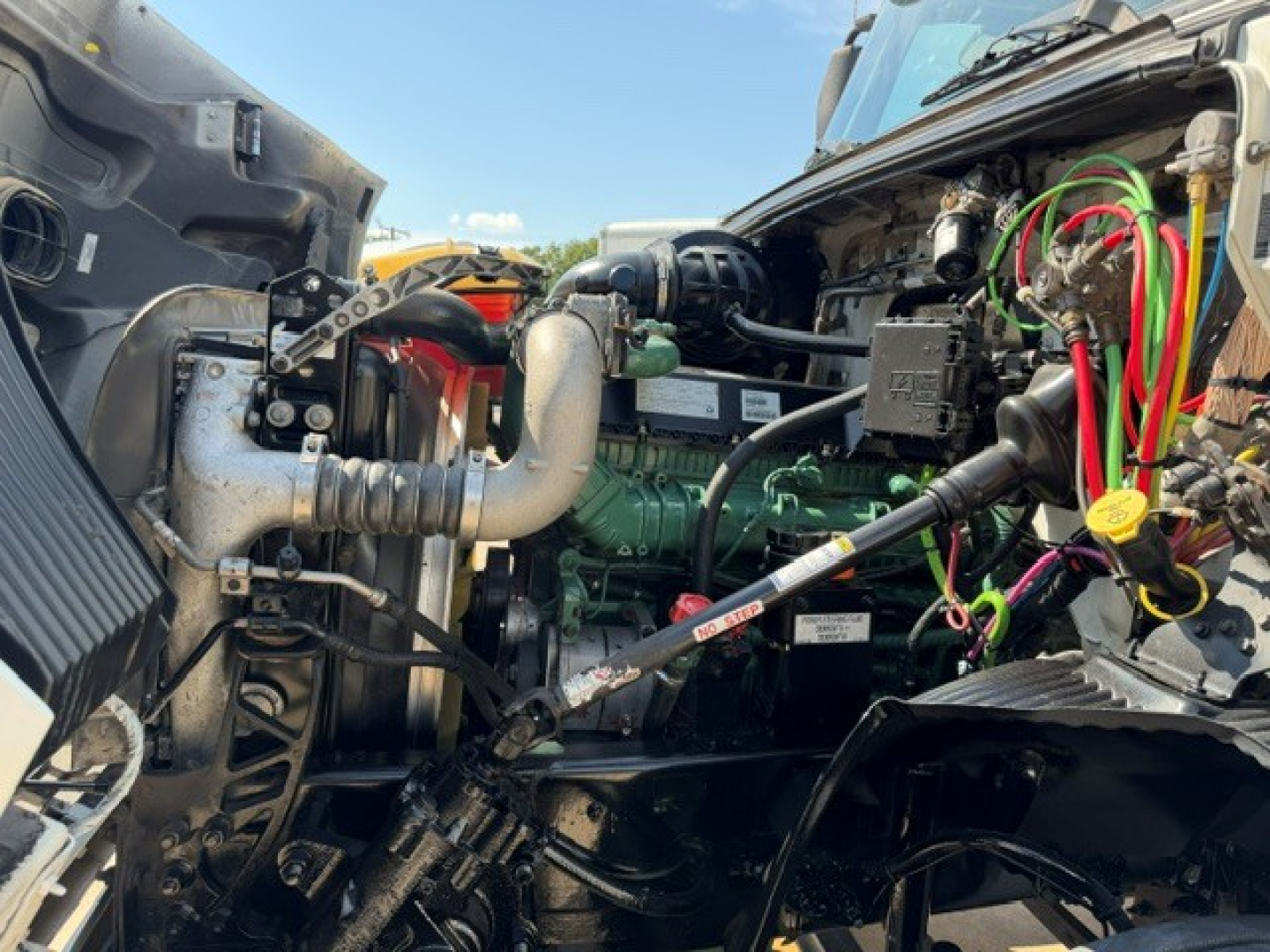Volvo VNR64T300 engine bay showing fabric hoses, wiring, and turbocharger plumbing under open hood.