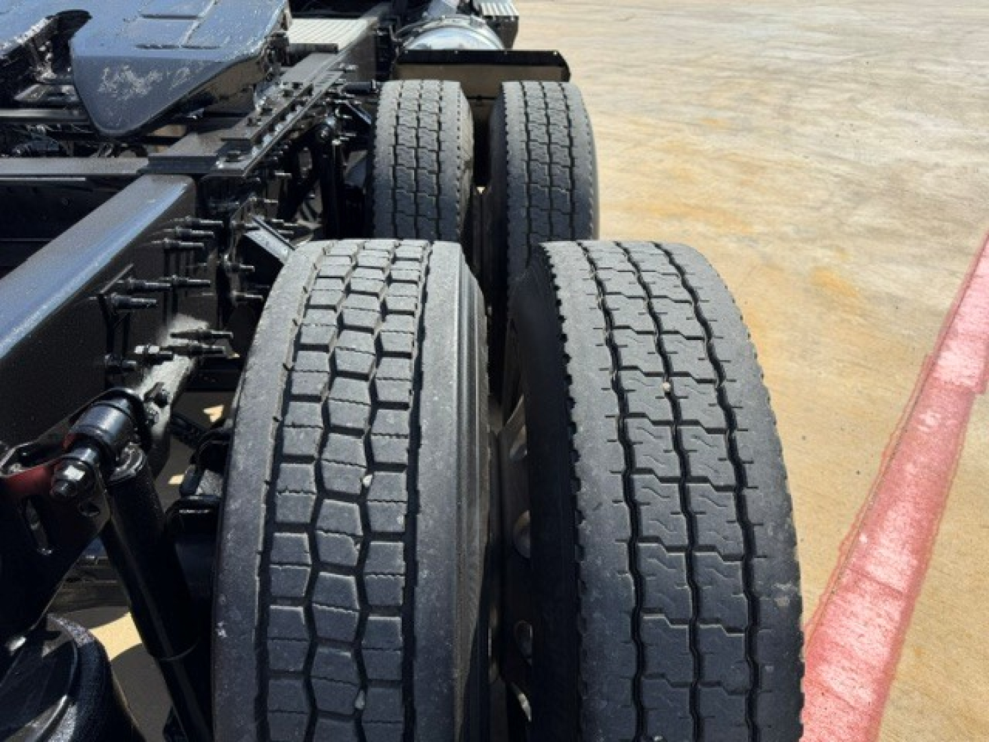 Vehicle rear triple-axle setup on a Volvo VNR64T300 with dual rear tires and chassis components visible.