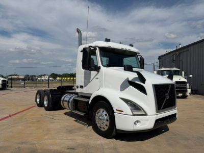 Volvo VNR64T300 daycab tractor in white, front-left view with chrome wheels and diesel tanks visible