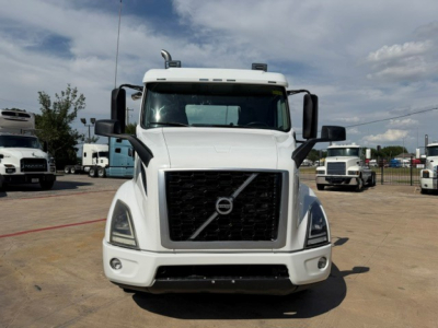 Volvo truck front view showing large black grille with Volvo emblem and headlights.