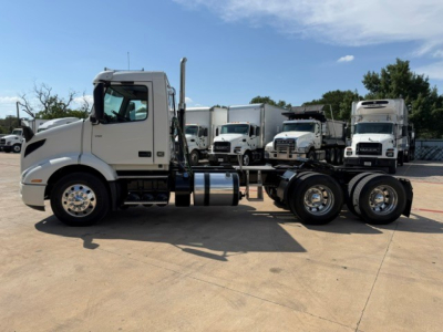 2018 Volvo VNR64T300 conventional daycab tractor side view showing cab, fuel tanks, air tanks, and dual rear axles with chrome wheels.