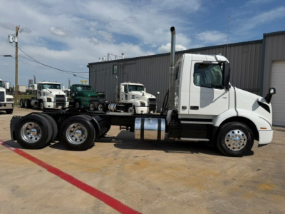 Volvo VNR64T300 truck chassis in a lot showing side view with white cab and dual rear axles.