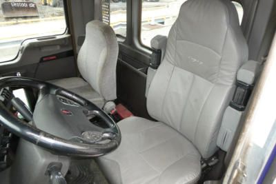 Kenworth T660 cab interior showing steering wheel and seats.