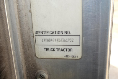 Identification plate showing VIN 1XKAD49X4DJ361932 on a Kenworth T660 truck part of the identification label area.