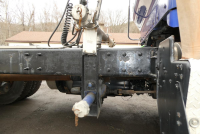 Kenworth T660 chassis with hitch and hydraulic lines visible in side view, undercarriage with black steel frame and suspension components.
