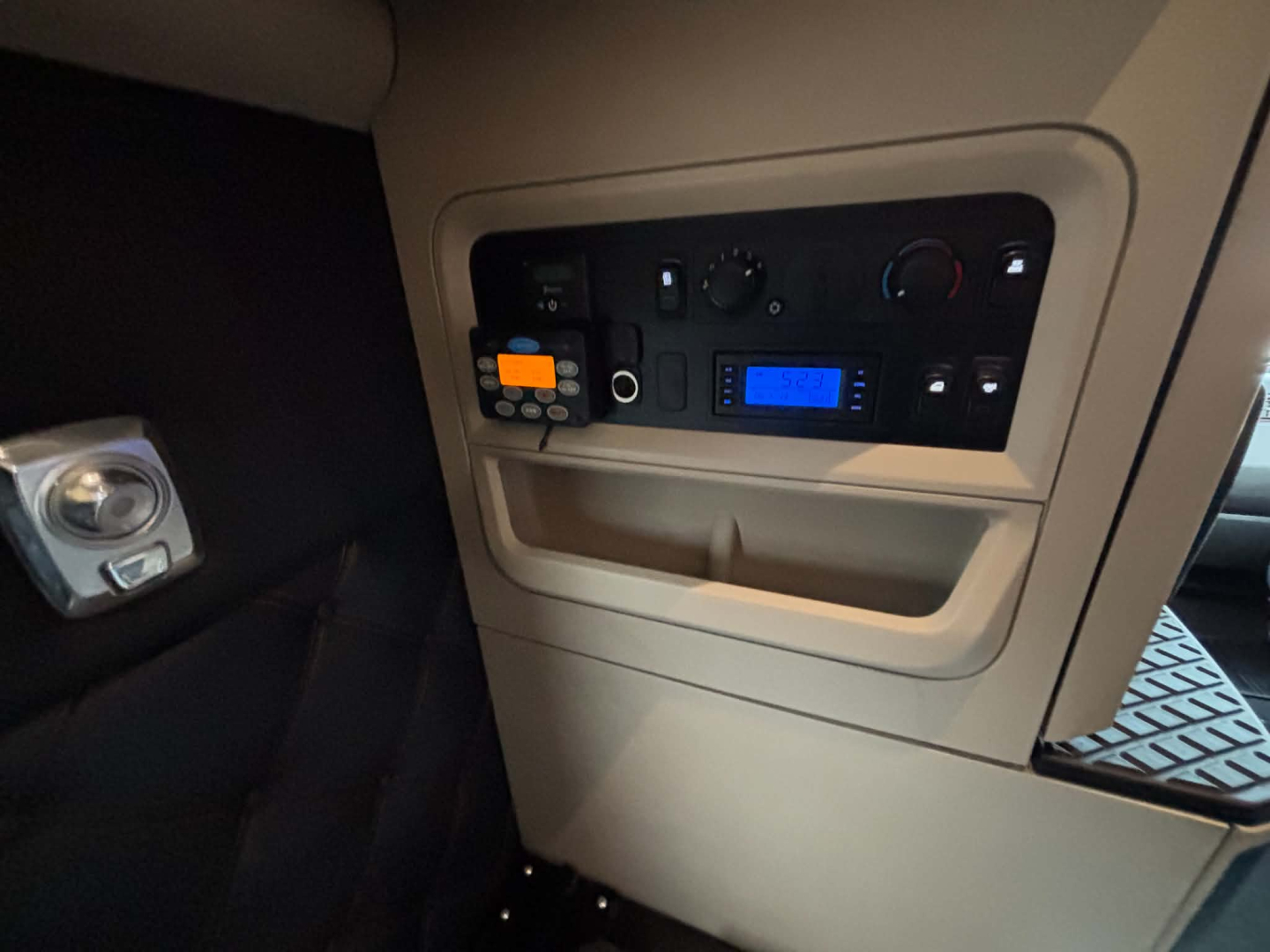 Kenworth T680 cab interior showing dashboard controls, climate knobs, blue digital display, and control panel.