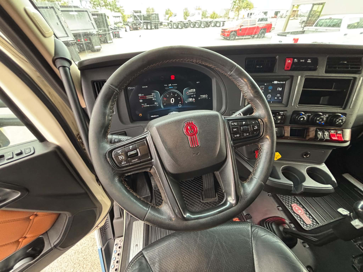 Kenworth T680 interior view showing steering wheel, dashboard, and center console with digital gauge cluster.