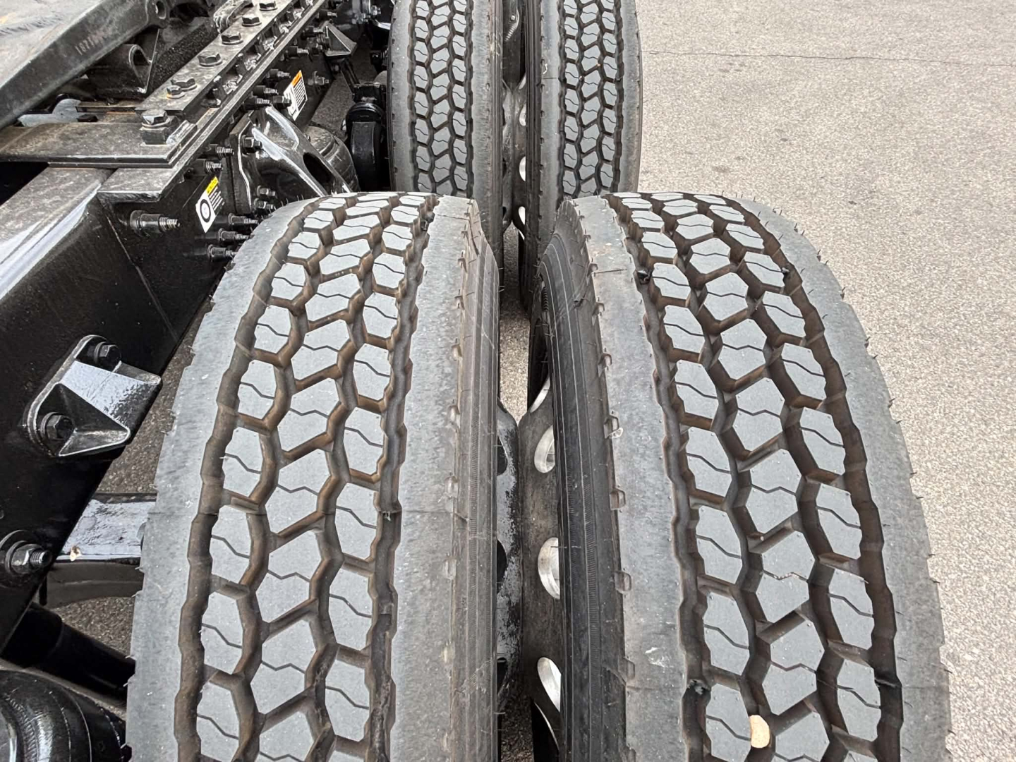 Kenworth T680 truck rear dual tires with tread pattern visible in the image view, chassis components and suspension nearby.