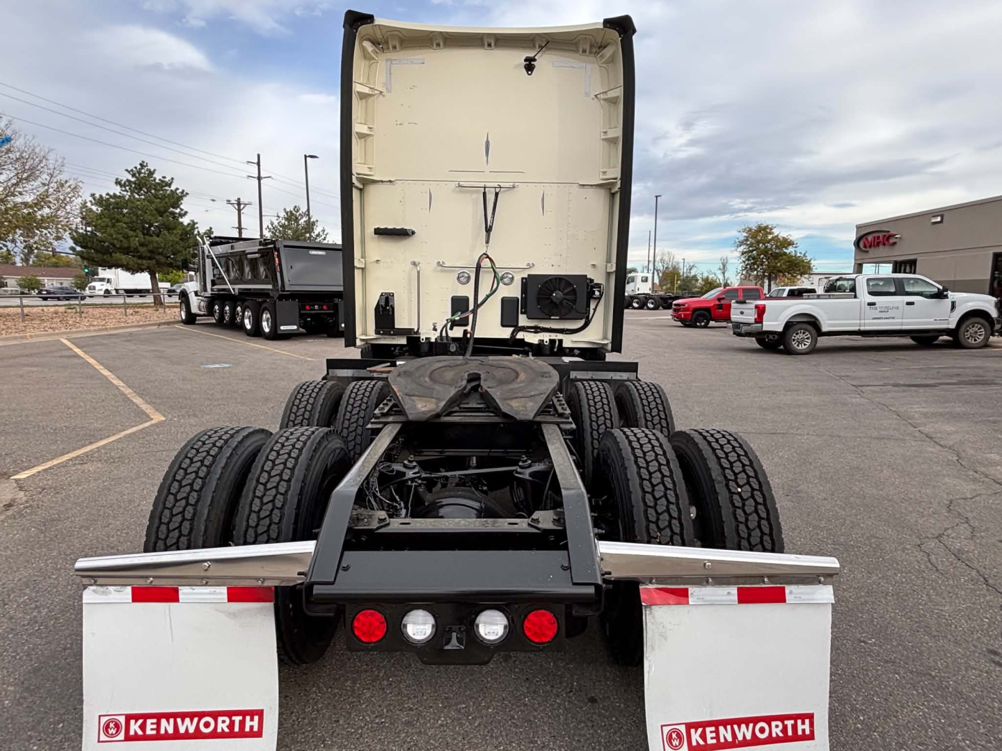 Kenworth truck rear view showing fifth wheel, dual rear axles, and rear bumper with Kenworth branding on mudflaps.
