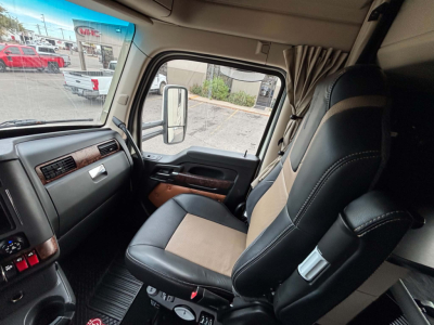 Kenworth T680 truck cab interior showing leather and fabric seat, steering area, and side window.