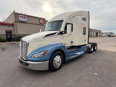 Kenworth T680 semi-truck in service bay area showing aerodynamic sleeper cab and dual rear axles.