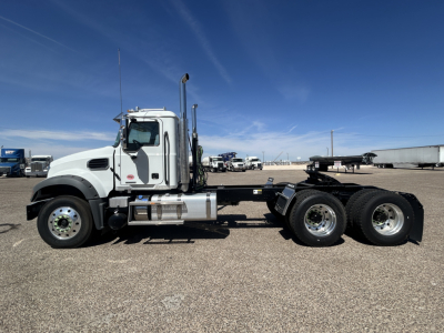 Mack GR64FT conventional daycab truck chassis side view showing cab and dual rear axles with fuel tanks and exhaust stack