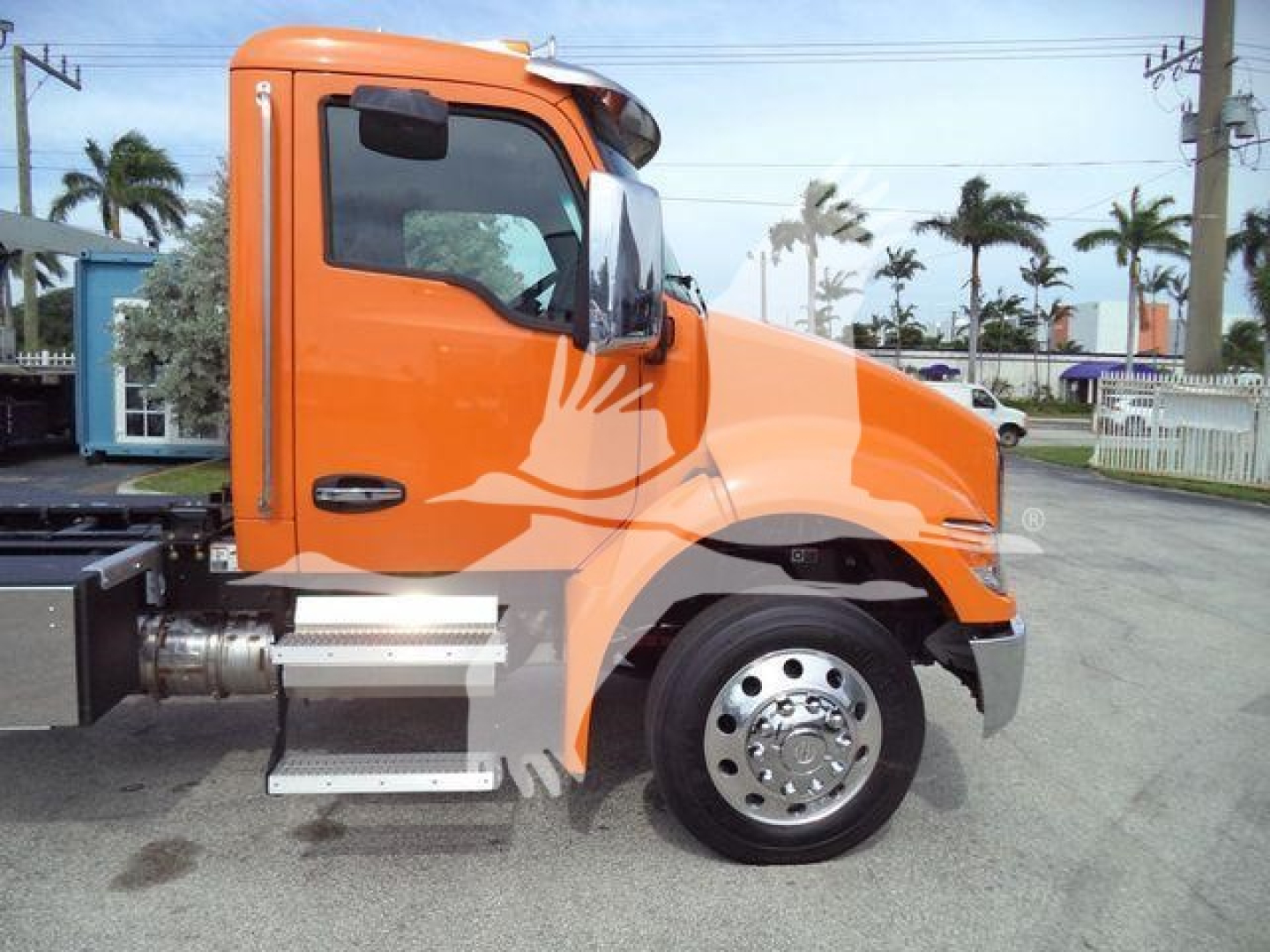 Orange Kenworth T280 rollback truck cab side view showing front wheel, side steps, and operator door with black handle.