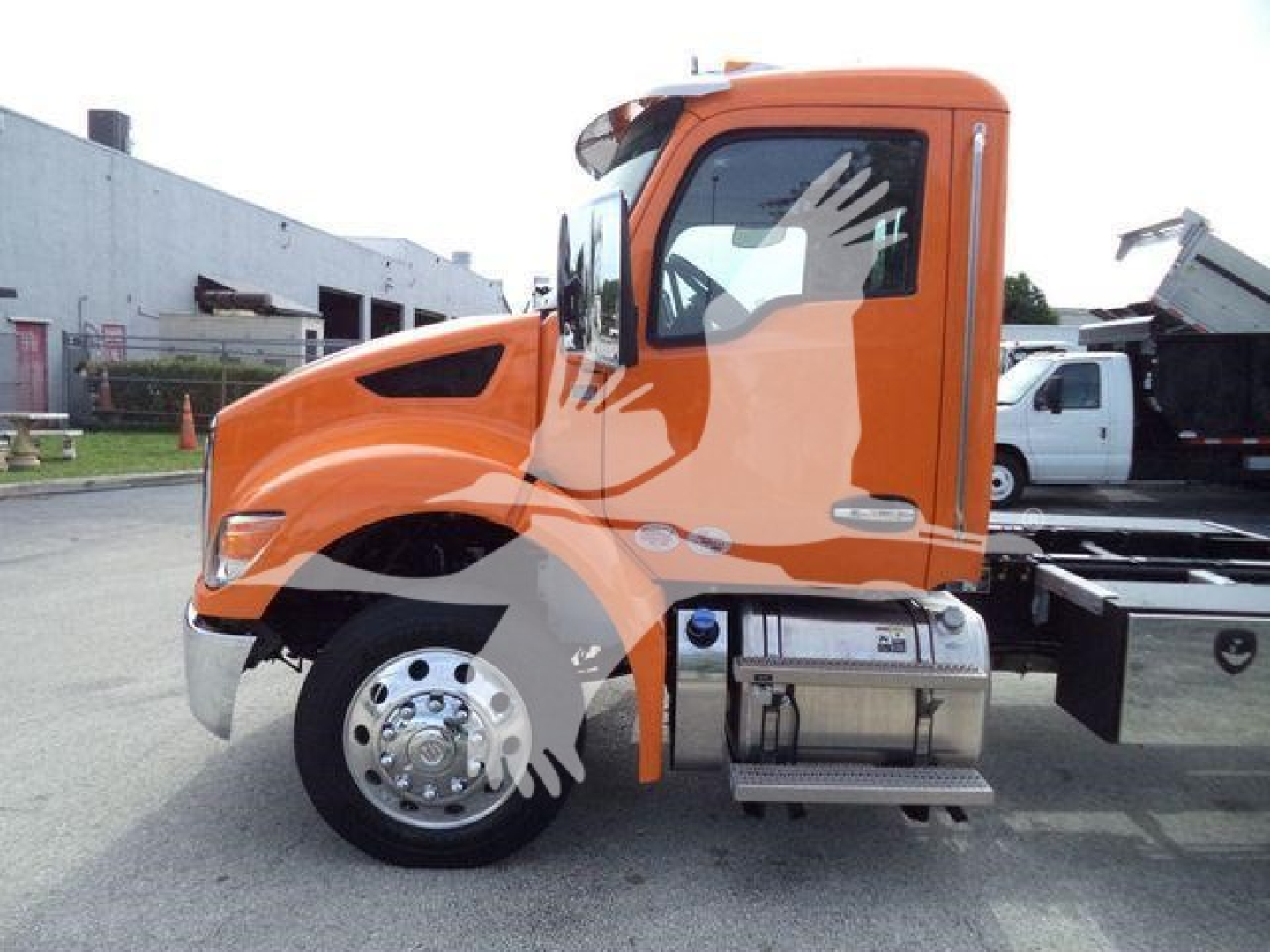 Orange Kenworth T280 cab with fuel tanks and chrome wheel, side view of truck, no visible text on body besides small badges